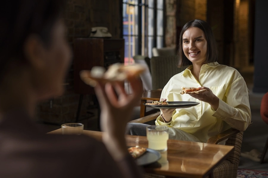Deux clients dans un hôtel en train de manger une pizza