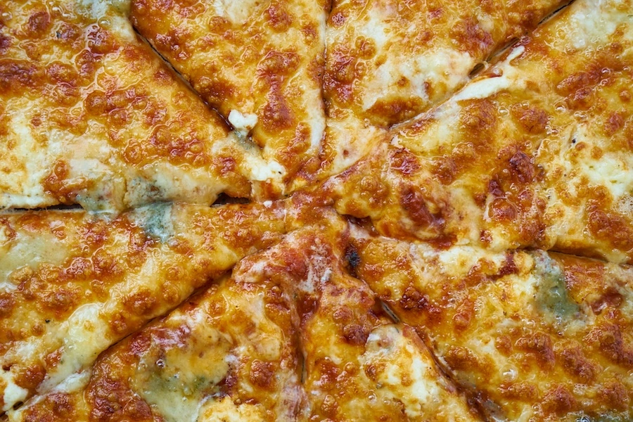Gros plan sur une pizza fromagère prédécoupée en parts, format snacking à forte marge